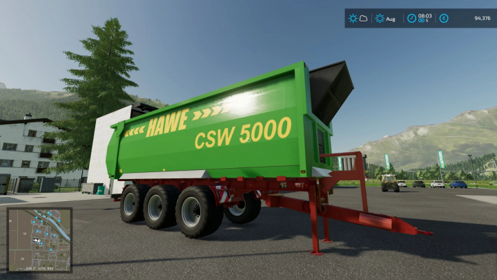 Mod FS22 Hawe CSW 5000 rimorchio in Farming Simulator 22, mostrando il suo design verde e rosso in un paesaggio suggestivo.