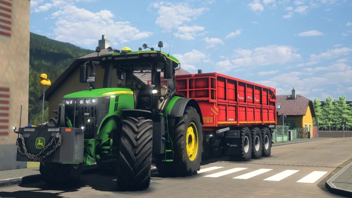 fs22-mods, John Deere 7R tractor mod in FS22, pulling a red trailer through a village street.