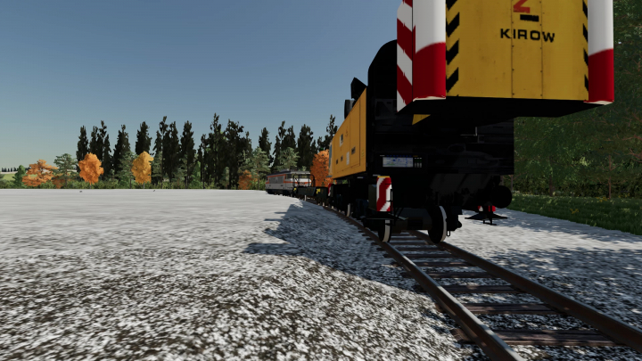 Mod FS22 Kirow multitasker T1200 en vías de tren en campo nevado, rodeado de árboles.