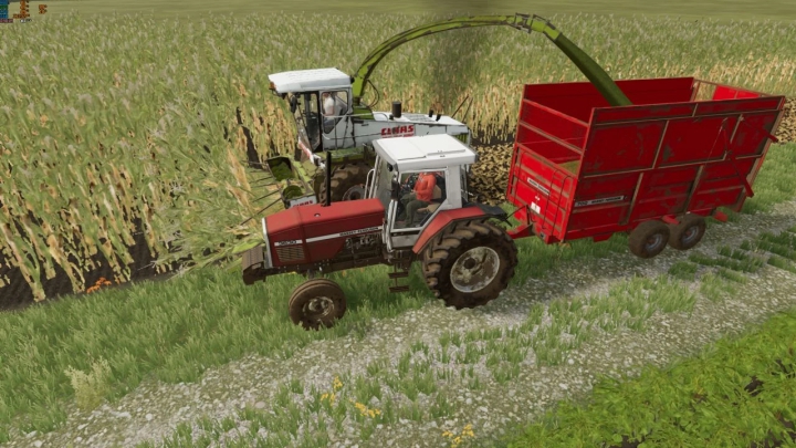 FS22 mod Massey Ferguson 700 tractor met rode aanhanger oogst maïsveld.