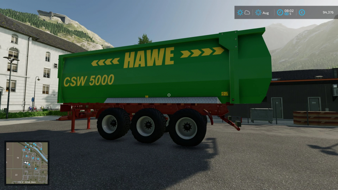 FS22 mod Hawe CSW 5000 przyczepa w Farming Simulator 22, prezentująca zielony design i potrójną oś w szczegółowym otoczeniu gospodarstwa.