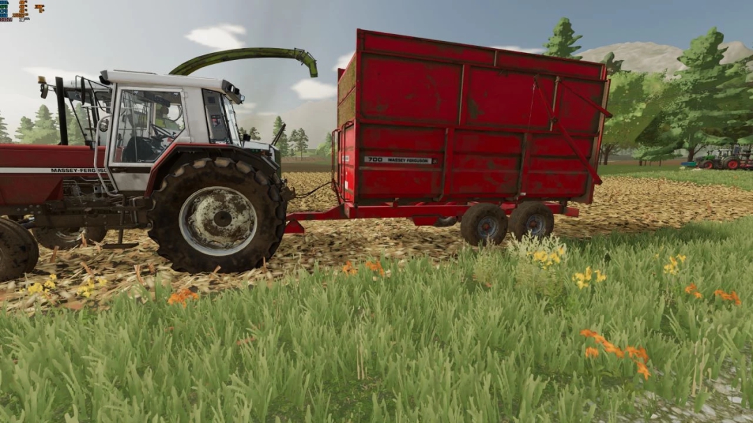 Mod FS22 Massey Ferguson 700 mostrando un tractor rojo tirando de un remolque en un campo con césped. Los mods de Farming Simulator 22 mejoran el juego.