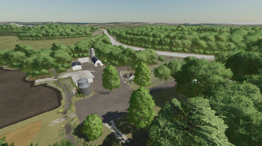 Luchtfoto van een boerderij in FS22-mod 'Save the Abandon Farm' met silo's, gebouwen en omliggend bos in Taheton County.