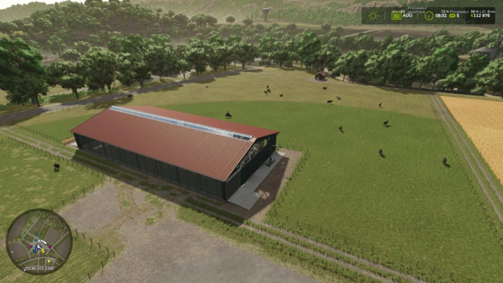 fs25-mods,  Aerial view of a cow stall mod in Farming Simulator 25, featuring a large red-roofed barn and grazing cows in a grassy field.