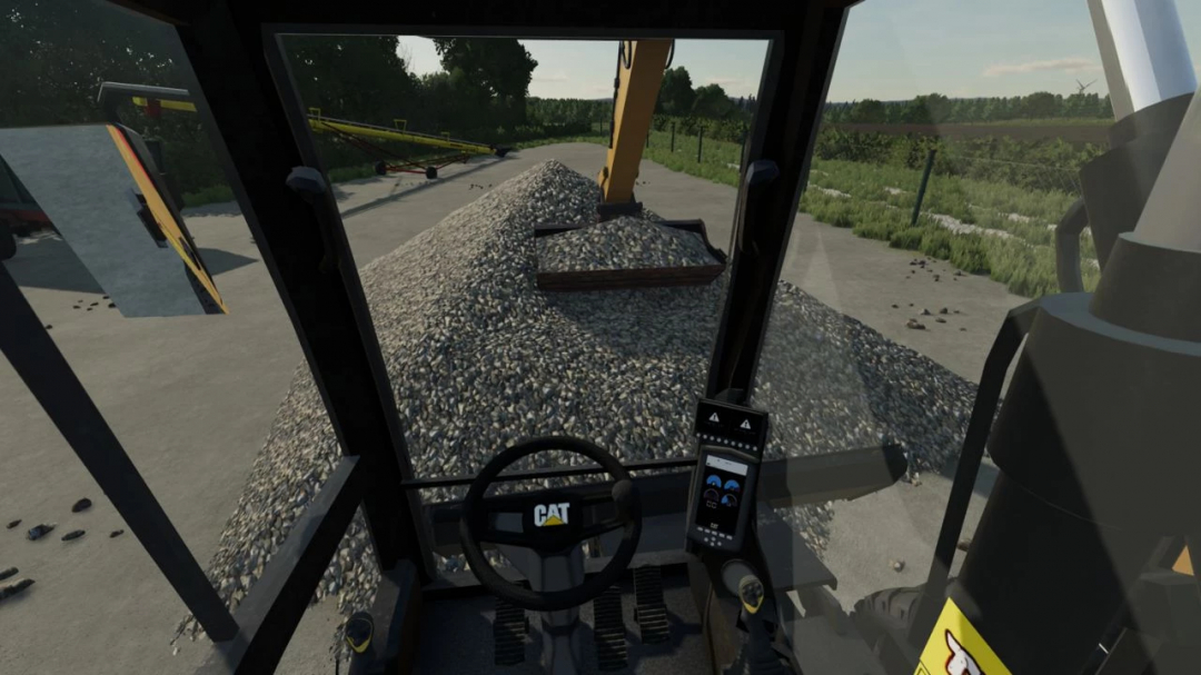 Interior view of Caterpillar M315F mod in FS22, showcasing controls and a gravel pile.