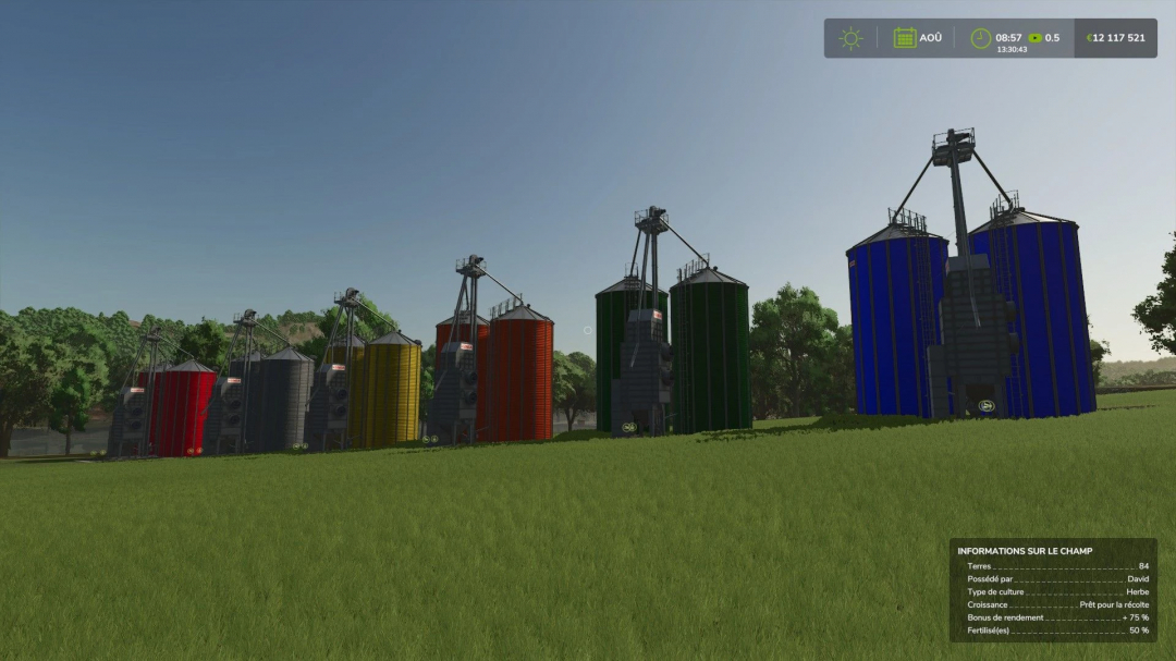 Silos coloridos del mod Mega Silo Multifruits en FS25 en un campo de hierba.