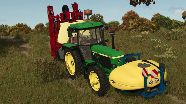 fs25-mods,  Mod FS25 Fronttank 1100L Delvano przymocowany do zielonego traktora na trawiastym polu.