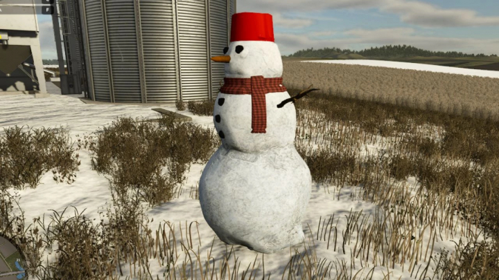 fs25-mods,  Snowman mod in FS25 with a red bucket hat and scarf near a silo. Farming Simulator 25 mods enhance winter landscapes.