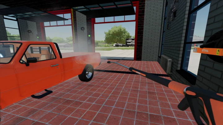 fs22-mods, FS22 mod showing wall-mounted Stihl high pressure washer cleaning orange truck in garage.