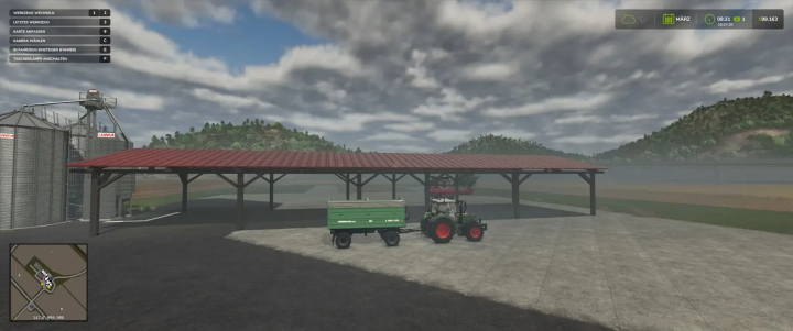 fs25-mods,  Holzunterstand-Mod in FS25 mit einem Traktor und Anhänger unter rotem Dach vor bewölktem Himmel.