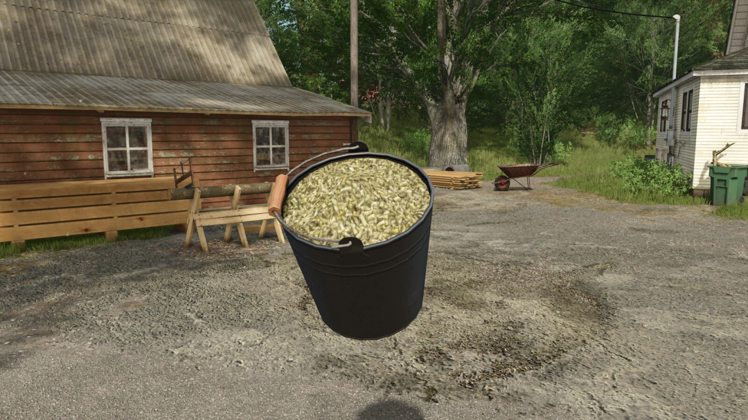 FS25-mod Bucket v1.0.0.0 toont een gevulde emmer in een rustieke boerderijomgeving.