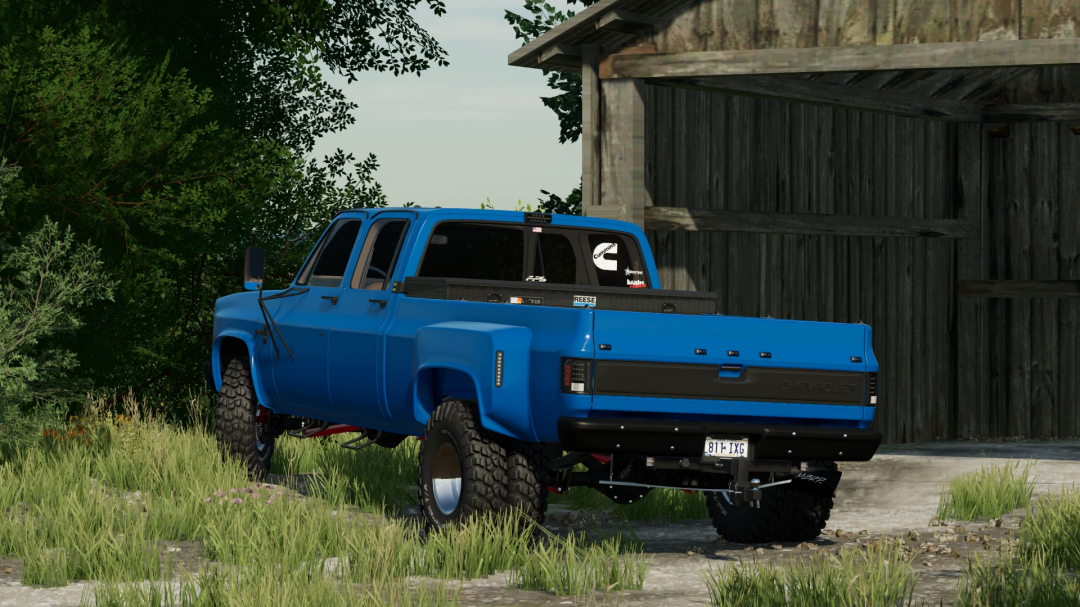 FS22 mod Chevrolet K30 Dually v1.2.0.0 in blue, parked by a barn in Farming Simulator 22.