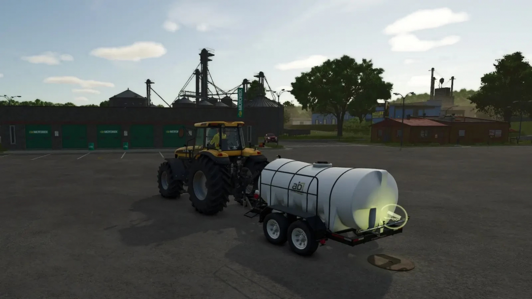 Mod FS25 Drain v1.0.0.0 montrant un tracteur avec remorque à réservoir près d'un bâtiment agricole.