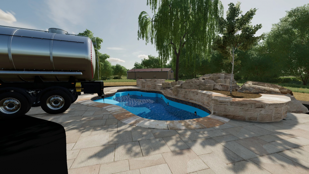 Mod FS22 Piscina Recarregável v1.1.0.0 mostra um caminhão tanque enchendo uma pequena piscina ao ar livre cercada por pedras.