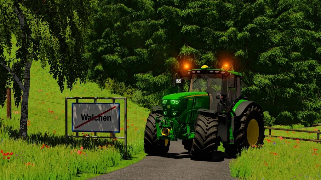 Trattore John Deere 6R Series nel mod FS22 su strada rurale vicino a una foresta e segnale.