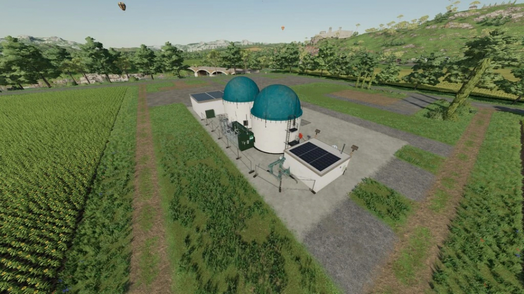 Aerial view of a biogas facility in FS22 Processing Of Bales And Chaff mod, surrounded by lush fields and trees.