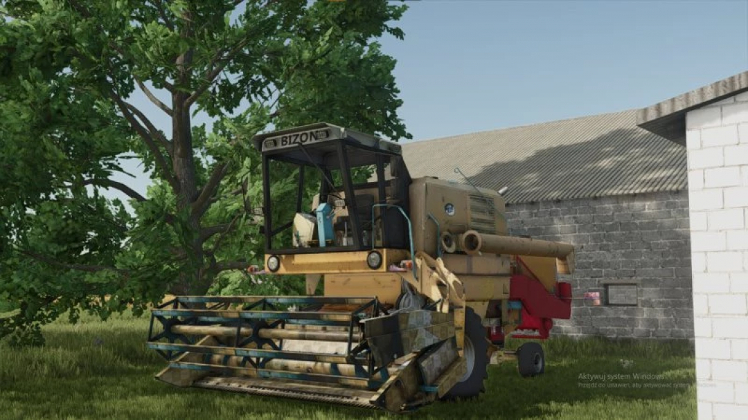 FS25 Mini village mod features a vintage Bizon harvester near a barn among trees in Farming Simulator 25.