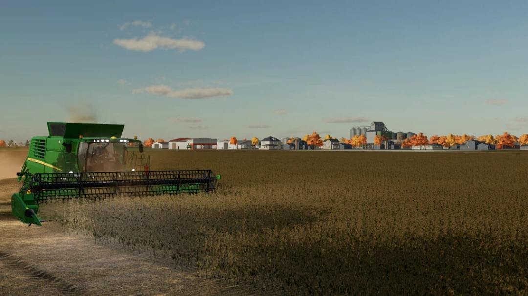 Mähdrescher arbeitet auf einem Feld auf der Gnadenthal-Karte in FS22. Herbstbäume und landwirtschaftliche Gebäude im Hintergrund.