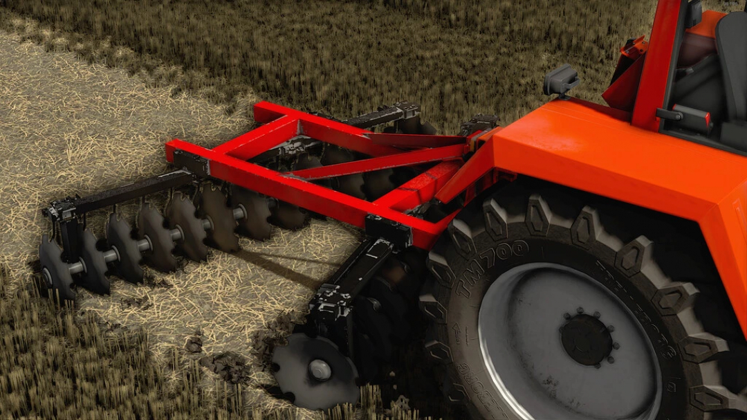 Mod Lizard Disc Harrow V26 pour Farming Simulator 22 fixé à un tracteur, affichant son cadre rouge robuste et ses lames de disque noires en action.