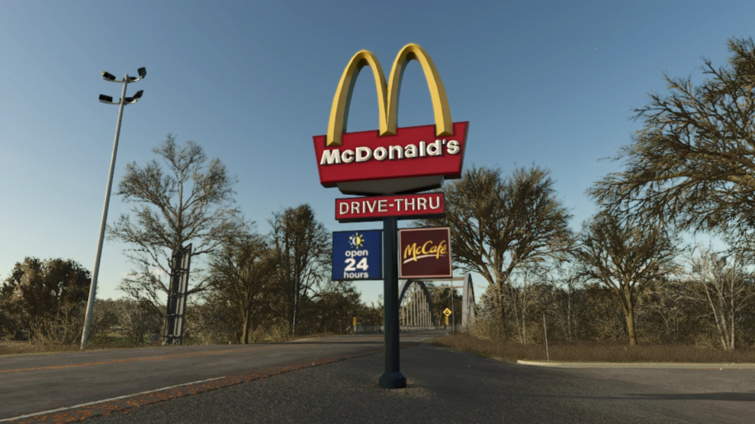 FS25 mod McDonald's Drive-Thru Sign seen in a rural setting, showcasing open 24 hours and McCafe signs under clear sky.