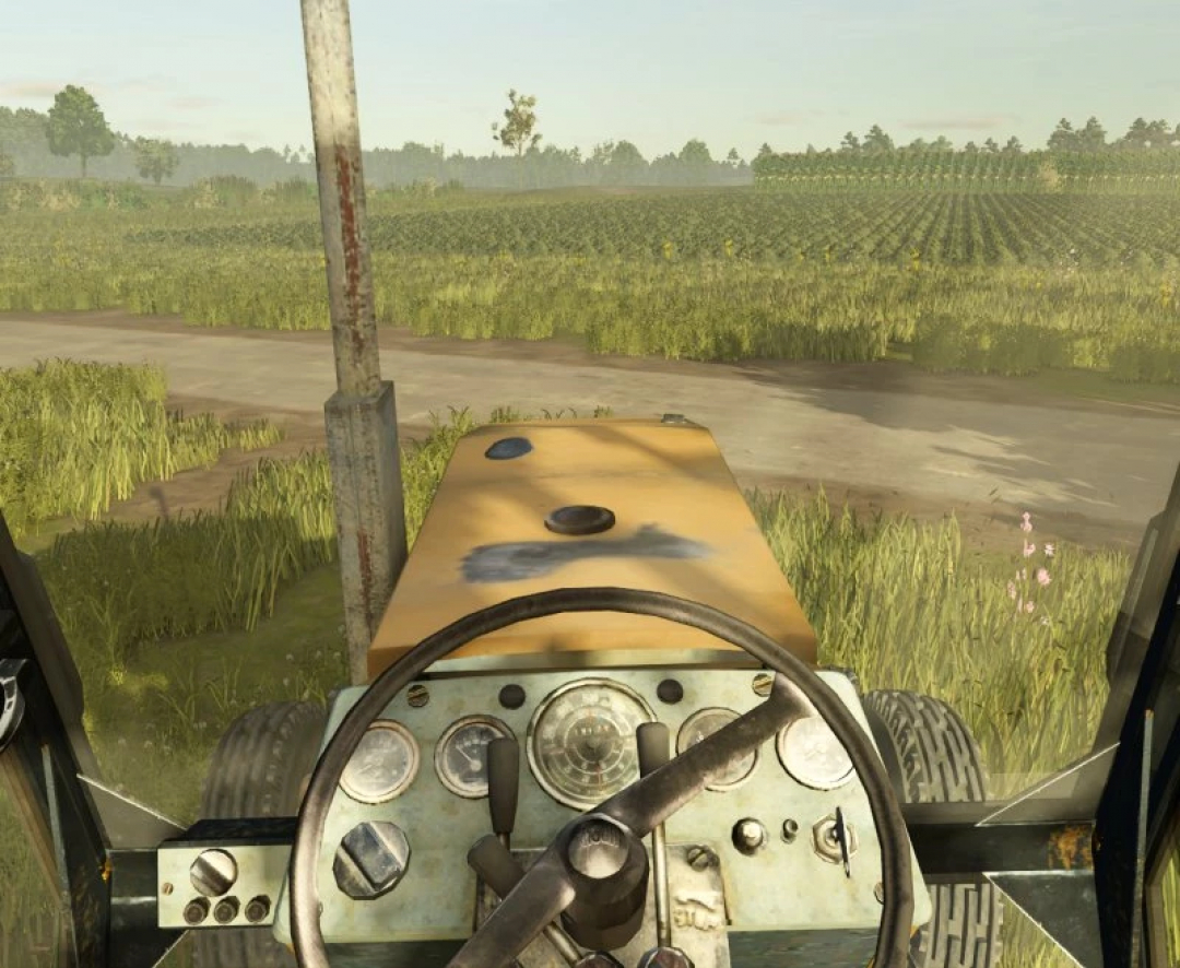 View from Ursus 920 tractor in FS25 mod, showing steering wheel and farmland.