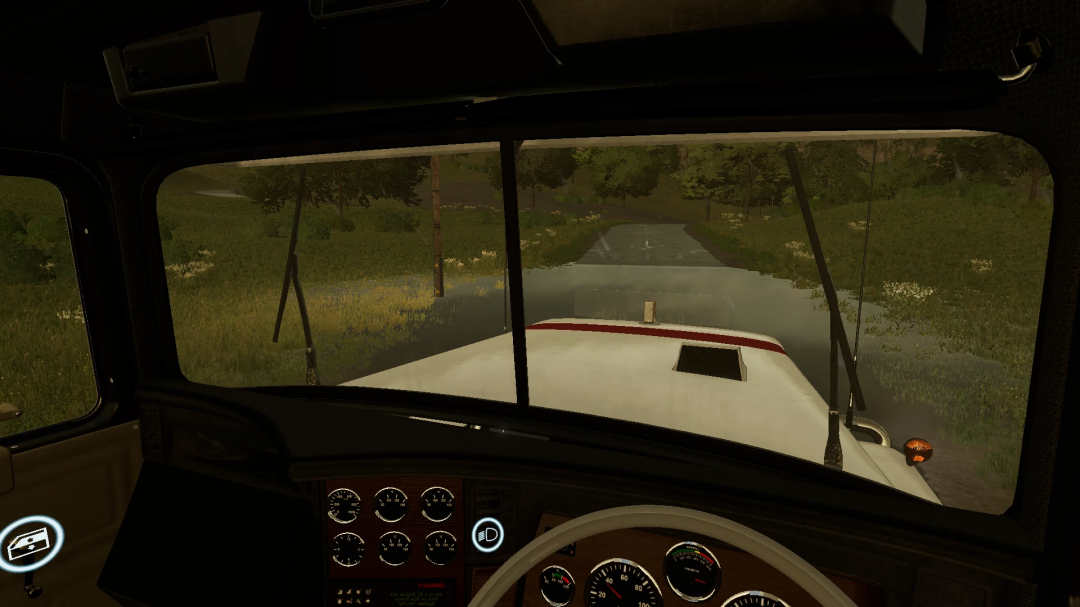 Interior view from Mack R700 truck in Farming Simulator 25, showcasing dashboard dials and a scenic road ahead.