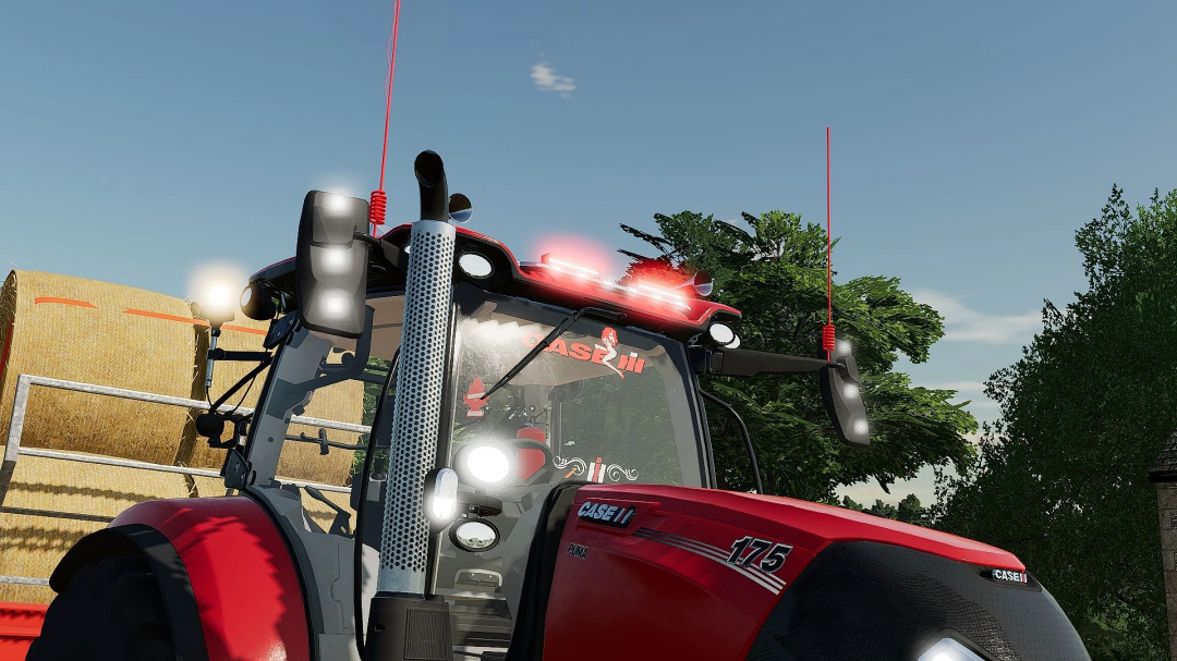 Close-up of Case IH Puma 175 tractor in FS22 mod, showcasing front lights and bale trailer.