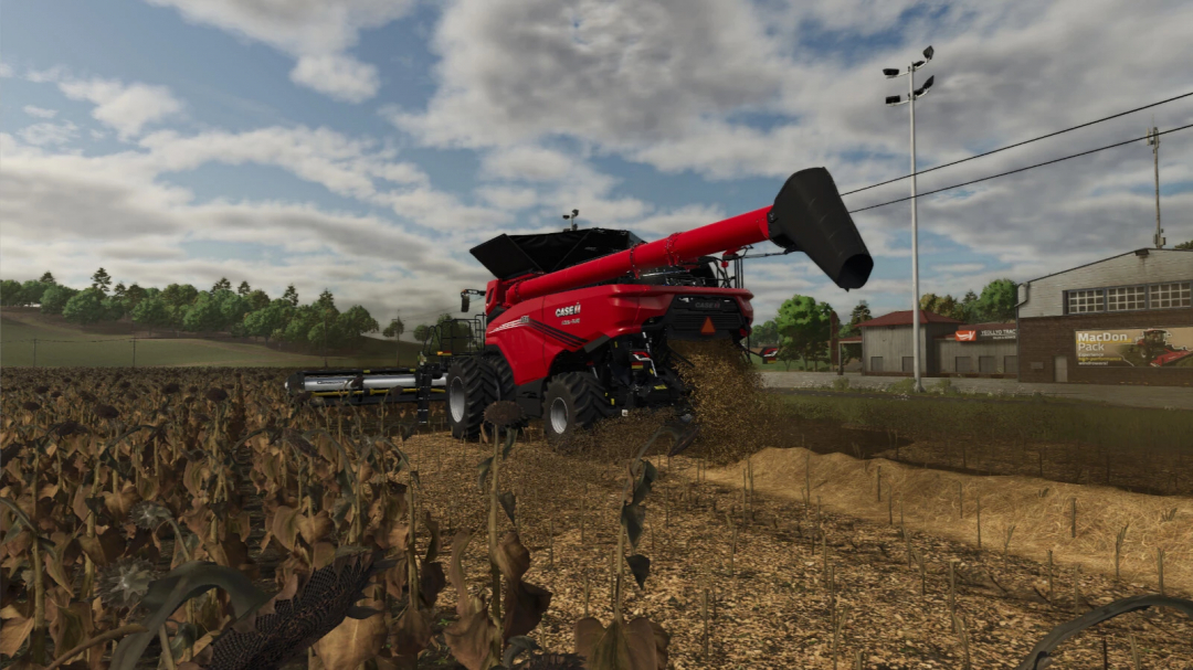 FS25 mod Extended Straw Crops v1.0.0.0 showing a harvester working on a field under a cloudy sky.