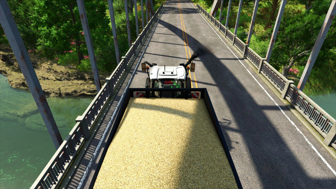 Fendt 700 Edit v1.0.0.0 mod in FS25, driving a trailer full of grain across a bridge.