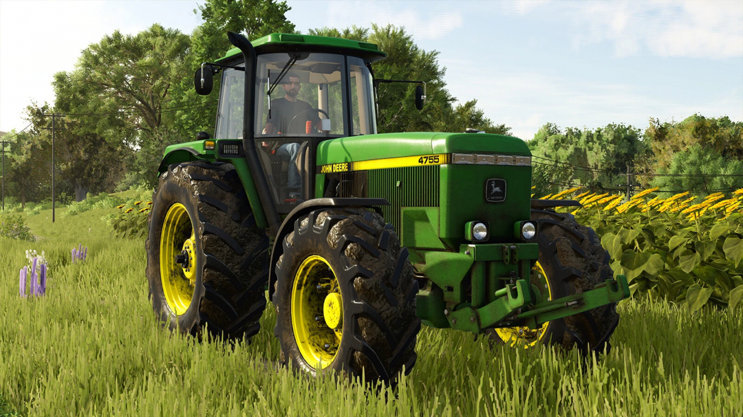 John Deere 4755 tractor mod in FS25 on field with flowers and trees.