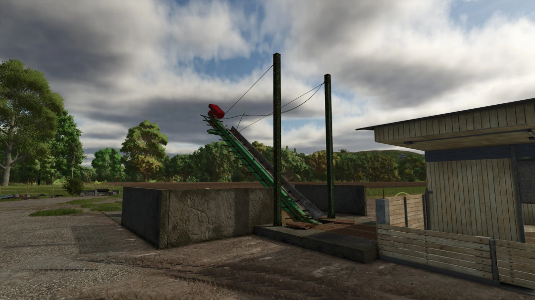 FS25 mod Manure Evacuator v1.0.0.0 in a farm setting, featuring a green conveyor system under a cloudy sky.