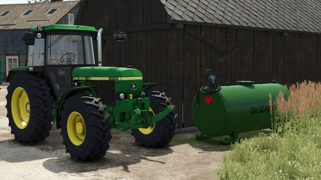 FS25 mod Old Fuel Tanks v1.0.0.0 with green tractor and fuel tank beside a barn.