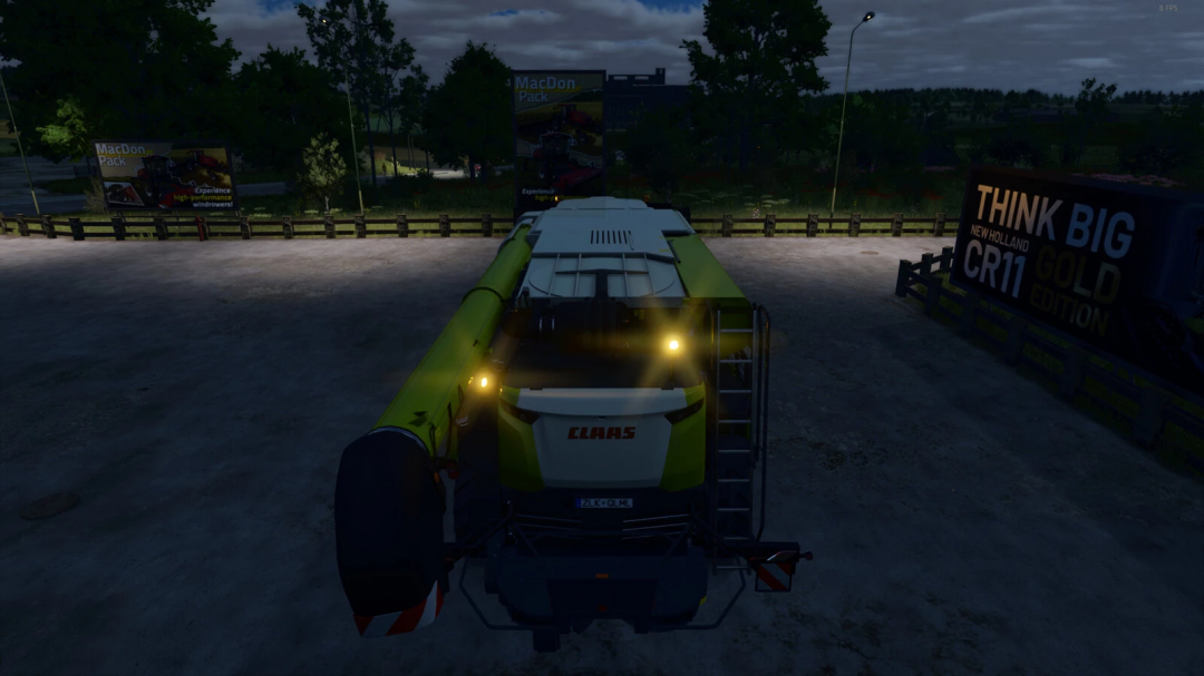 FS25 mods image showing a CLAAS harvester with beacon lights illuminated at night, featuring advertising billboards.