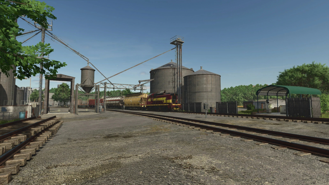 Train Stop mod in FS25, showcasing a train and grain silos at a loading area.