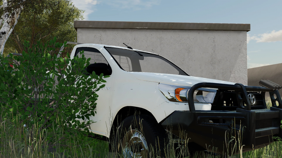 2021 Toyota Hilux Ute in FS22 mod, parked beside a building.