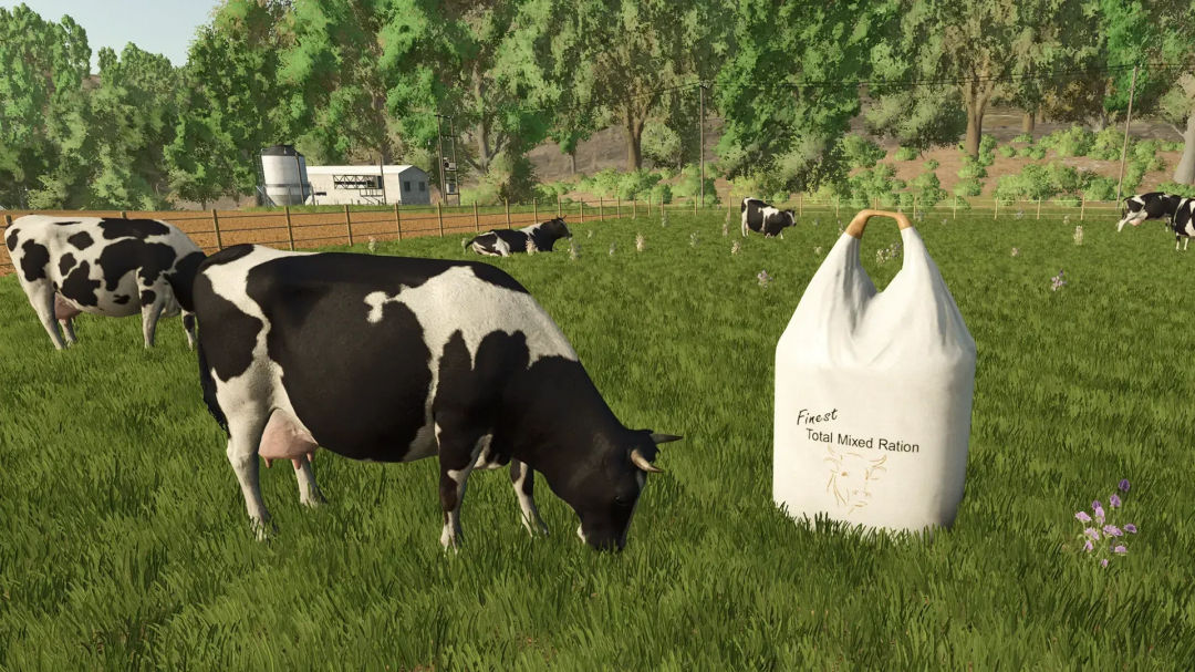 FS25 mod image of cows grazing near a Big Bag of Total Mixed Ration in a field.