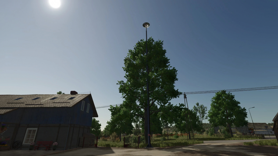 FS25 mod Fire Siren v1.0.0.0 in a rural setting with large trees and a house under a clear sky.