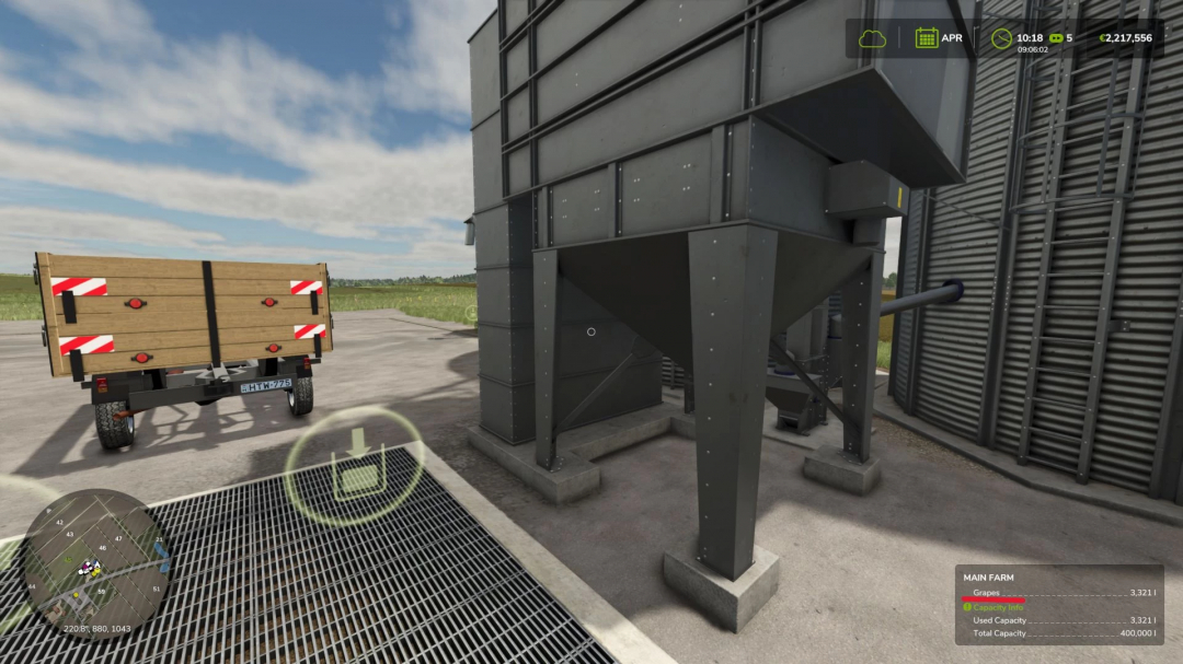 FS25 mod Grapes for all v1.0.0.0 showing a grape storage facility with a trailer nearby.