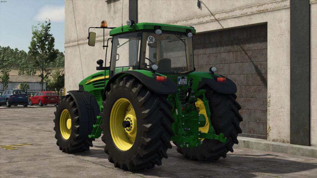 John Deere 7020 tractor mod in FS25, showcasing rear view with large yellow wheels, parked by a building.