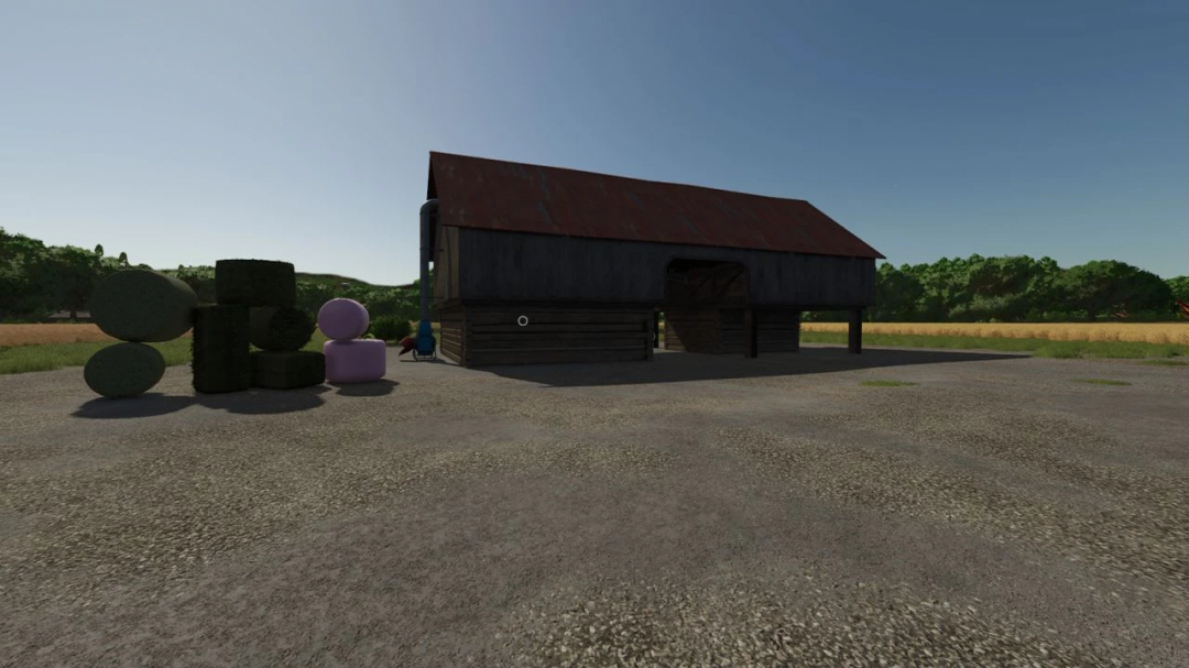 FS25 Real Feed Pack mod v2.1.0.1 showing a barn with stacks of hay bales outside.