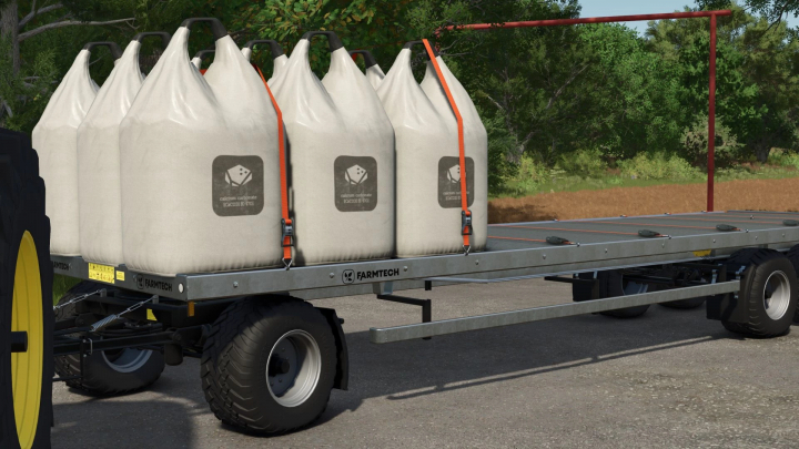 fs25-mods,  FS25 mod Universal Autoload v0.0.0.15 showing a Farmtech trailer loaded with four large white bags secured by orange straps.