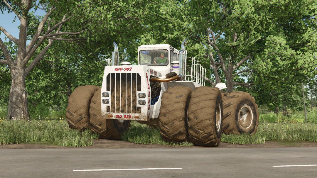 Big Bud 747 tractor in FS25 mod, showcasing its large muddy tires on a dirt road surrounded by trees.