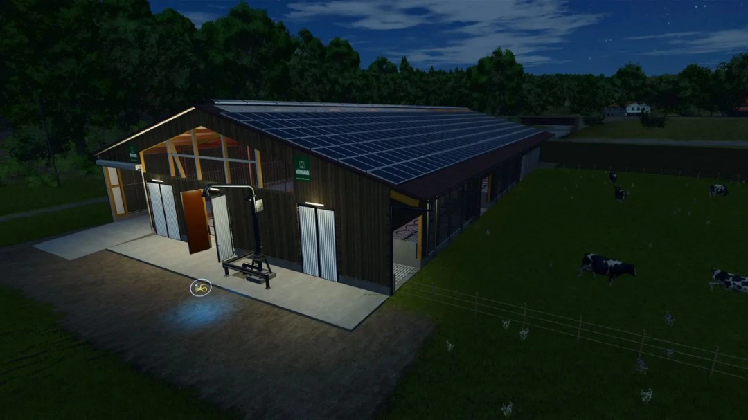 FS25 mod showing a large stable with a wood-look facade, lit at night, with cows grazing nearby.