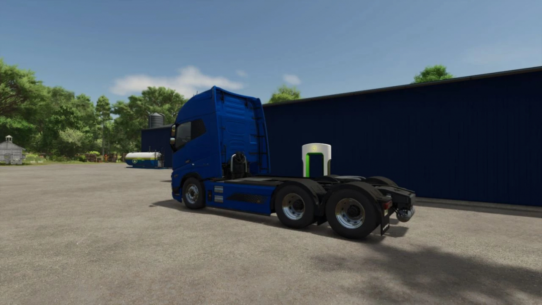 FS25 mod Super Charger Station x5 v1.0.0.3 features a blue truck parked beside a modern electric charging station in a farm setting.