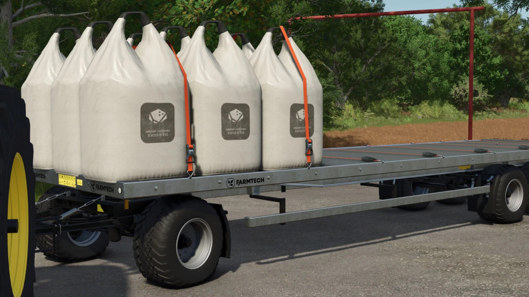 FS25 mod Universal Autoload v0.0.0.14: Farmtech trailer with large white sacks filled with calcium carbonate secured by straps.