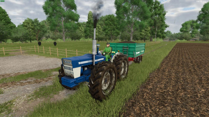 fs25-mods, FS25 mod County 1124 tractor with trailer on a farm path, surrounded by fields and cattle.