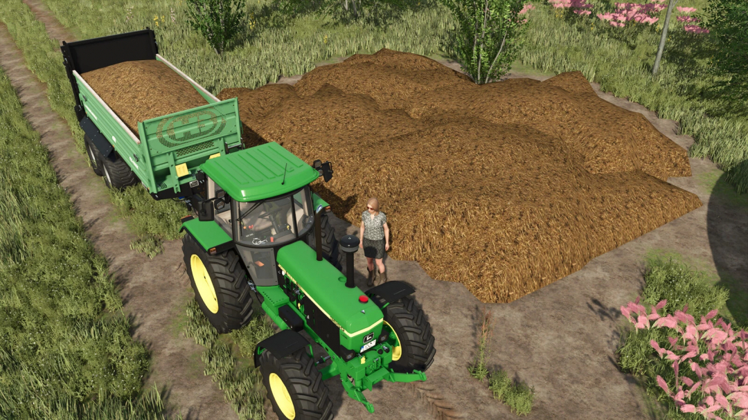 FS25 mod image showing a green tractor next to a trailer loaded with slurry and manure on a farm.