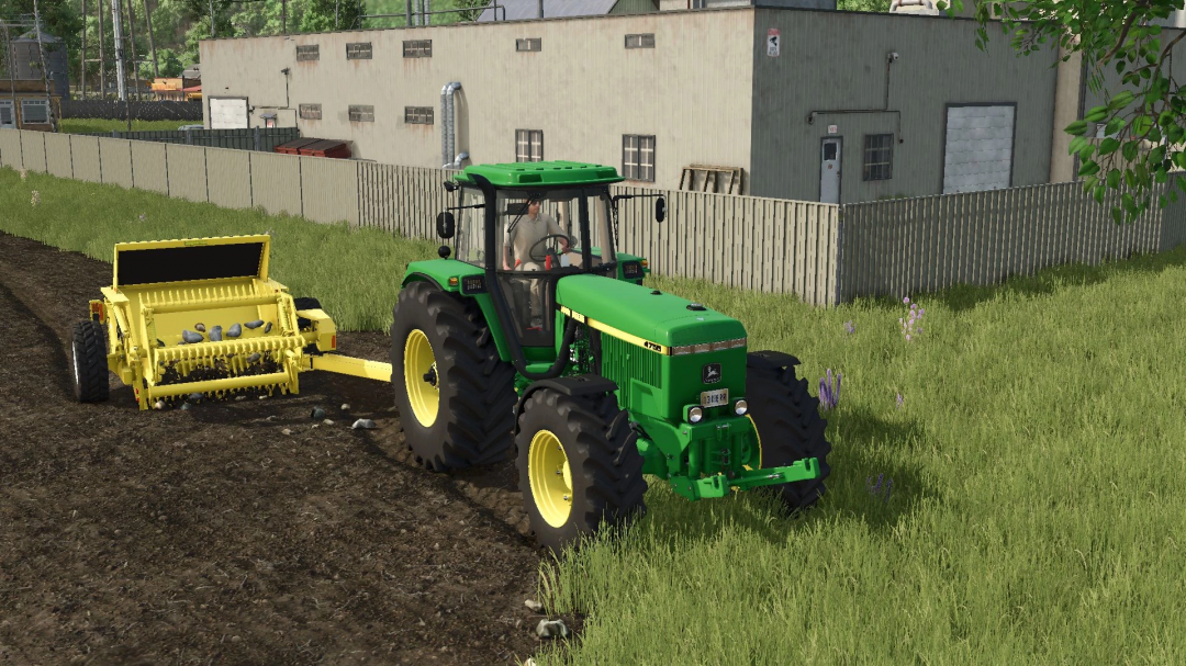 FS25 Degelman Rock Picker mod with green tractor on a farm.