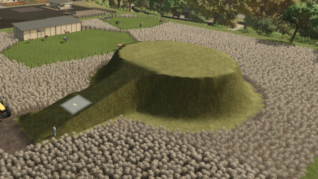 FS25 mod Free Terraforming And Painting v1.0.0.0 with a farm landscape featuring a large grassy mound surrounded by fields and a building.