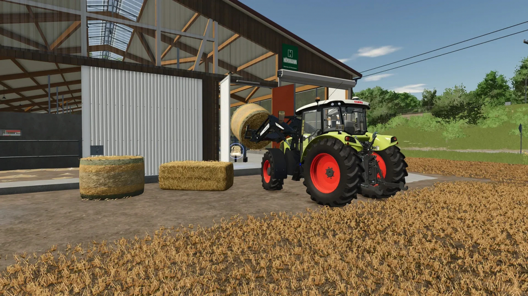 Tractor moving hay bales near a large cowshed in FS25 mod with wooden facade.